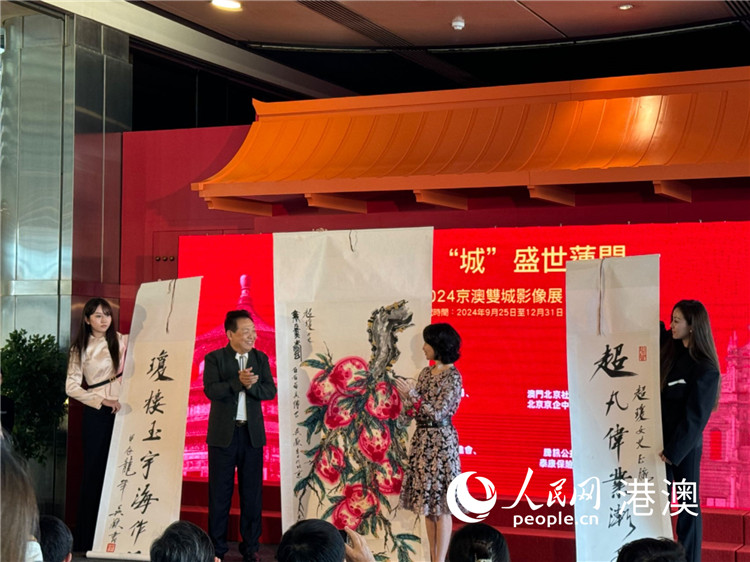 圖為吳歡向澳門北京社團(tuán)總會(huì)會(huì)長(zhǎng)何超瓊捐贈(zèng)作品。（本報(bào)記者富子梅攝）