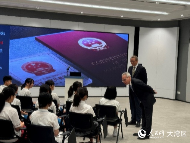 岑浩輝（右一）與正在傾聽普法講座的中學生們交流。人民網(wǎng)記者 富子梅攝