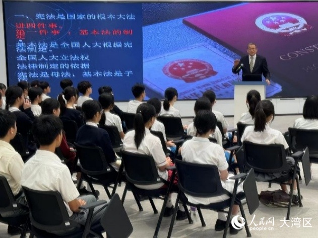 澳門大學法學院教授駱偉建在青少年普法講座上為中學生講解憲法和澳門基本法。人民網(wǎng)記者 富子梅攝