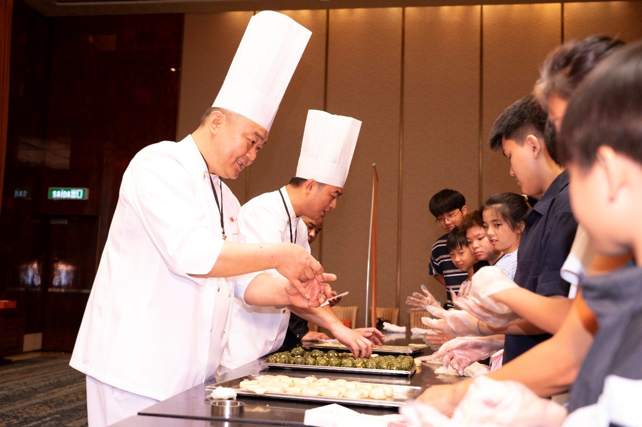 上海大廚現(xiàn)場(chǎng)手把手教小朋友們學(xué)習(xí)制作非遺點(diǎn)心。主辦方供圖