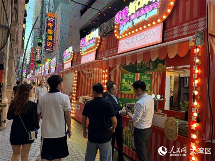 圖為游人在市集購買飲品。人民網(wǎng)記者 富子梅攝