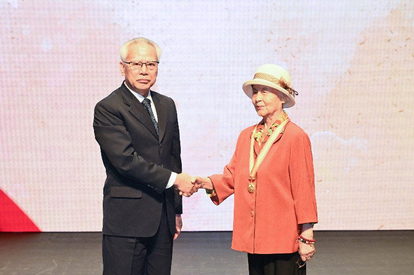 圖為岑浩輝向蔡俊烈士家屬梁鳳文女士頒發(fā)紀念章。澳門特區(qū)政府新聞局供圖