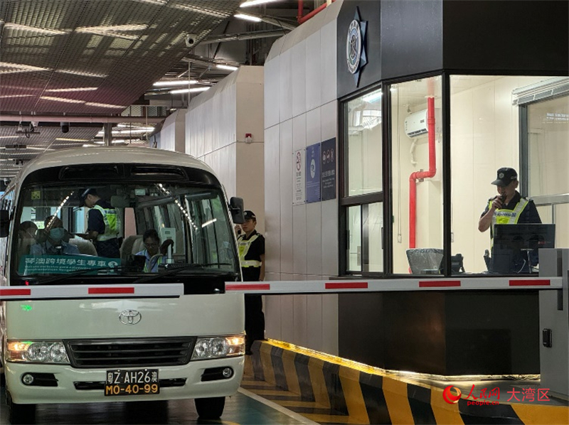 圖為第一輛跨境學(xué)生專車接受澳門海關(guān)登車查驗(yàn)、學(xué)生免下車通關(guān)服務(wù)新舉措。人民網(wǎng)記者 富子梅攝