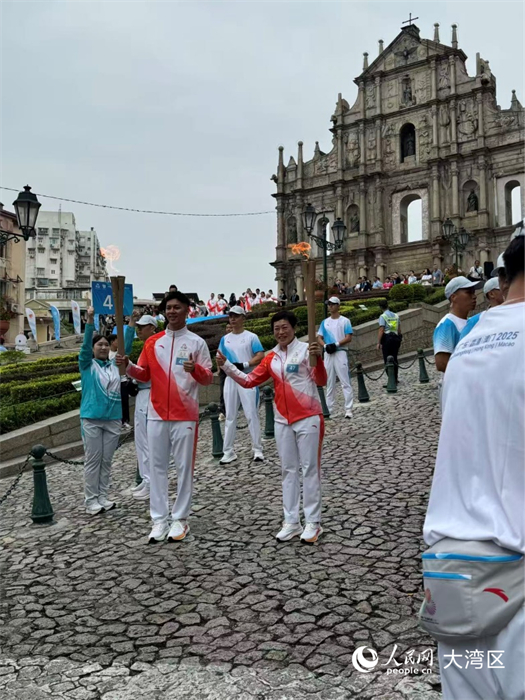 圖為第47棒和48棒火炬手在大三巴牌坊前交接。人民網(wǎng)記者 富子梅攝