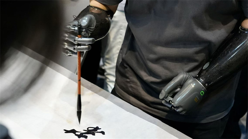 來自強腦科技的智能仿生手，依托佩戴者的神經電、肌肉電信號驅動，在現場展示書法創(chuàng)作。人民網 吳宇揚揚攝