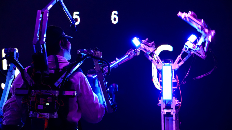 在AI互動(dòng)裝置《一路順風(fēng)》中，參與者穿戴專屬設(shè)備與機(jī)器人翩然共舞。人民網(wǎng) 吳宇揚(yáng)揚(yáng)攝