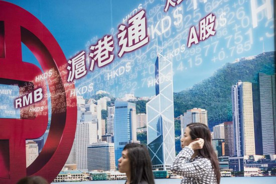 市民從香港中環(huán)一家銀行的滬港通廣告牌前走過。新華社記者呂小煒攝（資料照片）