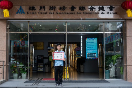 12月18日，澳門街坊會(huì)聯(lián)合總會(huì)的工作人員馮鴻俊在展示祝福語(yǔ)。