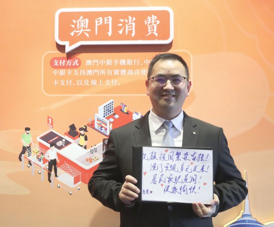 12月18日，澳門中銀員工王金思在展示祝福語(yǔ)。
