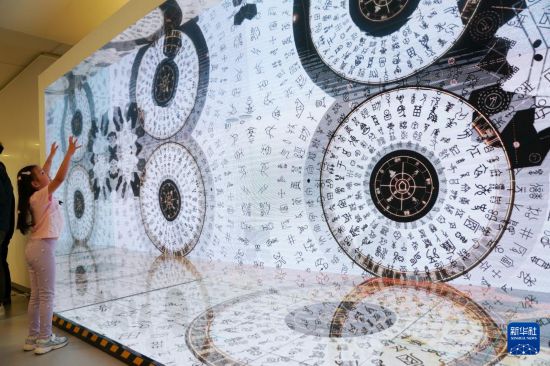 7月11日，在香港中央圖書館，小女孩被甲骨文的視頻動(dòng)畫吸引。新華社發(fā)（王申 攝）