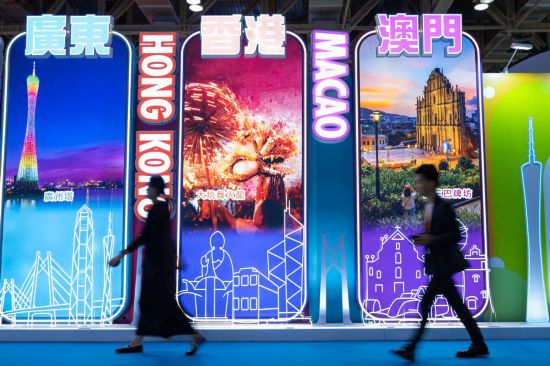 4月25日，參觀者從第十三屆澳門國(guó)際旅游（產(chǎn)業(yè)）博覽會(huì)大灣區(qū)展板前經(jīng)過。新華社發(fā)（張金加攝）