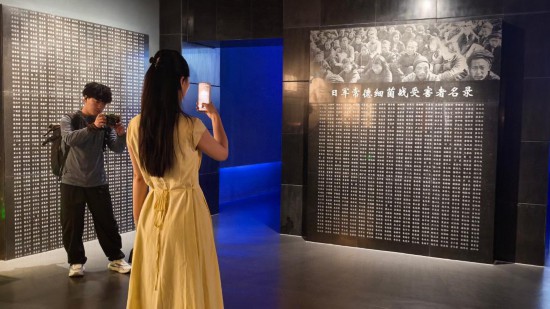 8月1日，采訪團(tuán)成員在常德博物館拍攝日軍常德細(xì)菌戰(zhàn)受害者名錄。新華社記者 馬欣然 攝