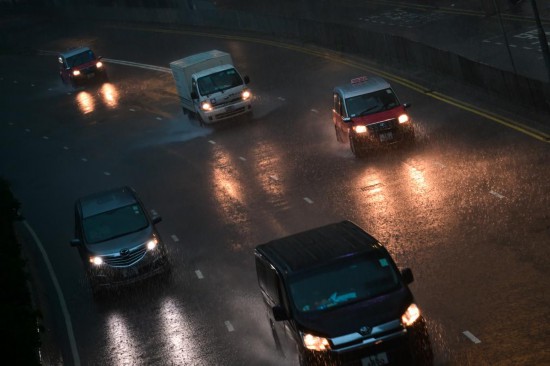 8月5日，車輛在香港街頭雨中行駛。新華社記者 朱煒 攝