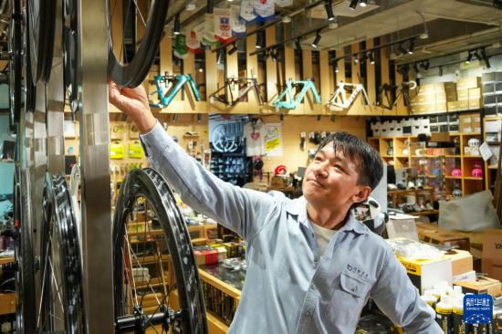 10月13日，在香港荃灣環(huán)貿(mào)廣場(chǎng)，黃金寶在他經(jīng)營(yíng)的單車店內(nèi)整理商品。新華社記者 朱煒 攝