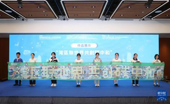 10月29日，參與活動的學生展示“灣區(qū)聯(lián)世界 共創(chuàng)碳中和”作品。新華社發(fā)