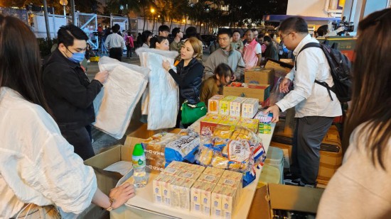 11月26日，受火災影響的居民在跨部門援助站領(lǐng)取救援物資。新華社記者 陳鐸 攝