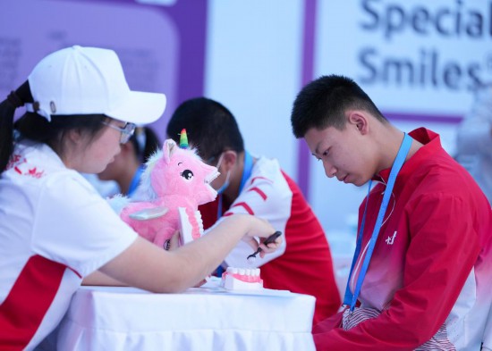 12月8日，在廣東省中山市體育館副館，工作人員為特奧運(yùn)動員普及護(hù)齒知識。新華社記者 楊晨光 攝