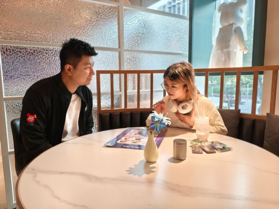 　　11月24日，劉承銘（左）在餐廳與食客交談。劉承銘在香港尖東經(jīng)營一家咖啡簡餐廳，從2024年夏天開始承辦游戲與動漫IP主題餐廳活動。新華社記者 劉英倫 攝