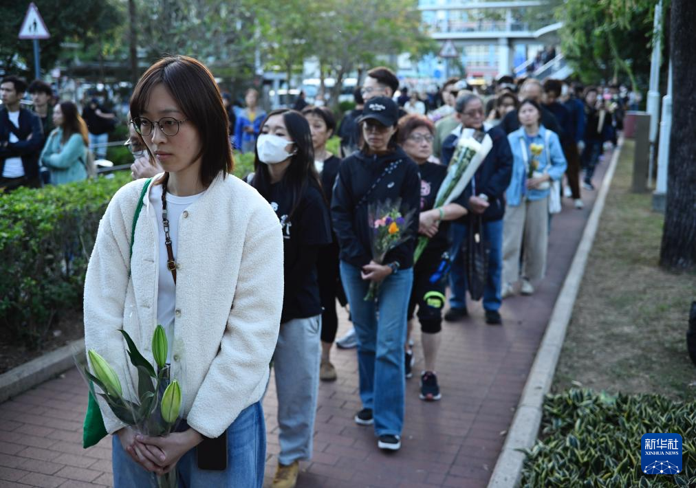 11月29日，在香港大埔宏福苑附近公園，人們排起長隊等待獻(xiàn)花。新華社發(fā)（王申攝）